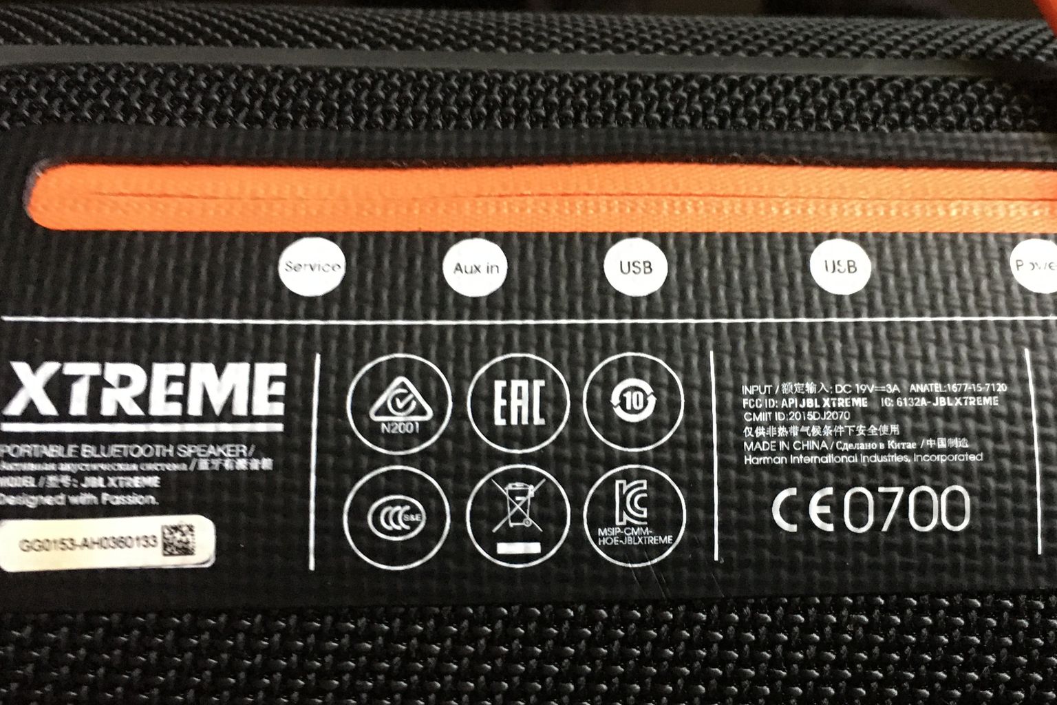 Close-up of the printed type plate on a portable Bluetooth speaker, showing the CE mark with notified body number 0700, an EAC mark, a NOM mark, a KC mark, a CCC mark, a crossed-out wheelie bin symbol and an FCC ID line