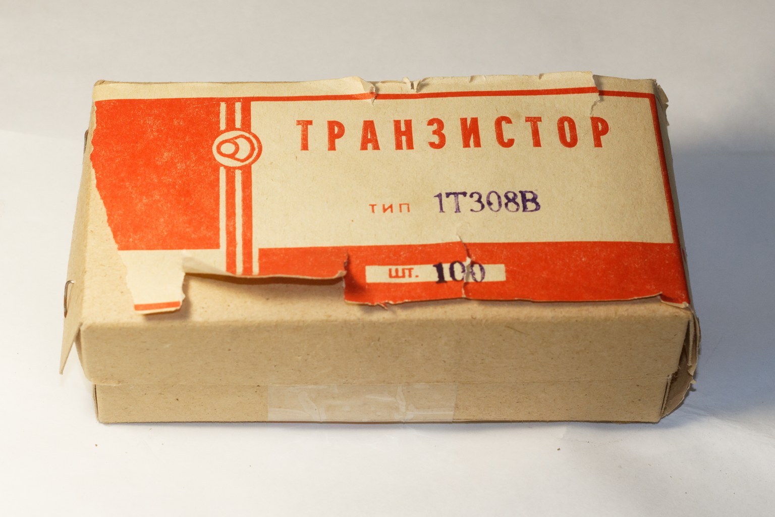 A vintage cardboard factory carton printed with the word TRANSISTOR, type 1T308V, and the quantity 100