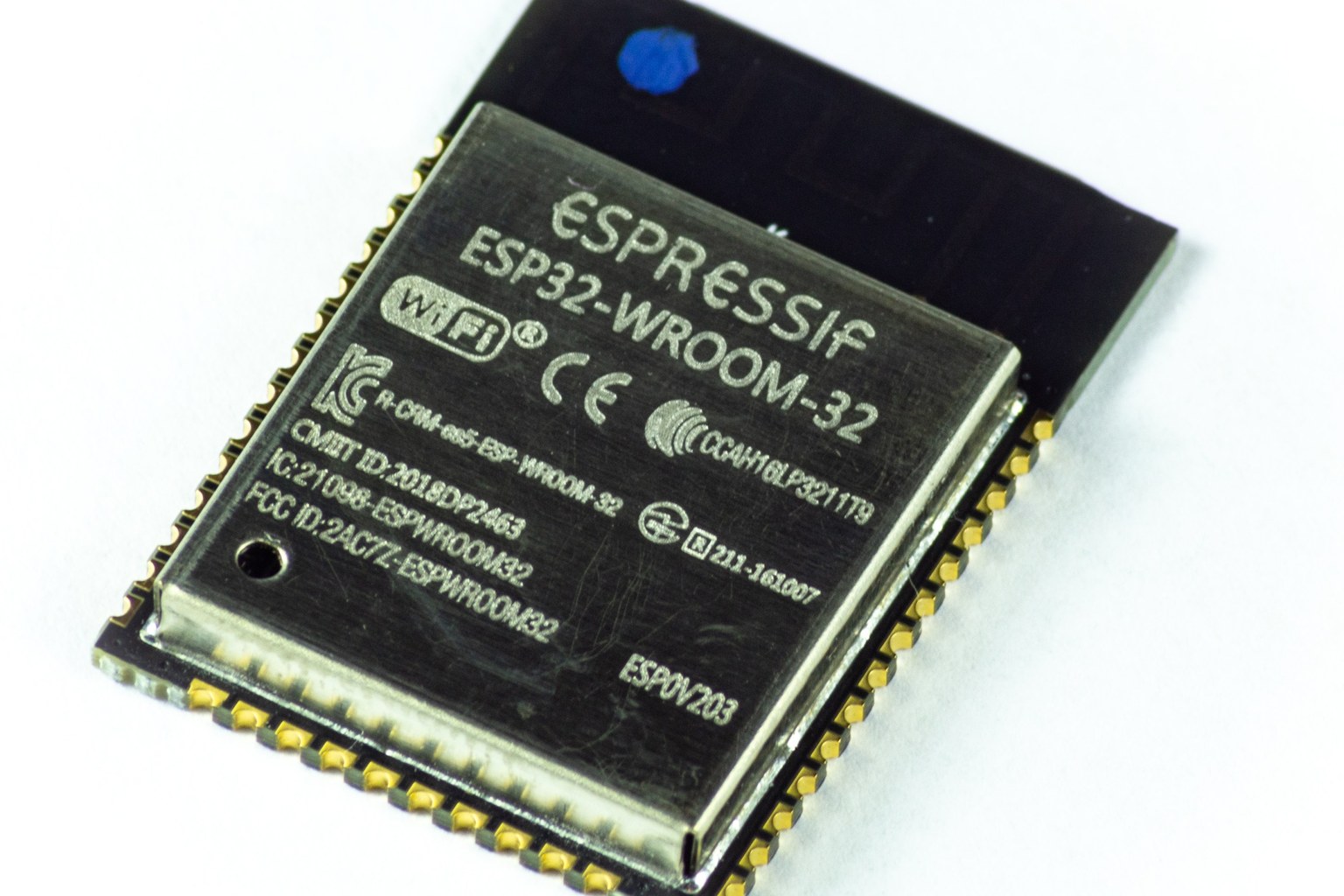 A shielded ESP32-WROOM-32 wireless system-on-module photographed on a white background, showing certification marks on the metal can